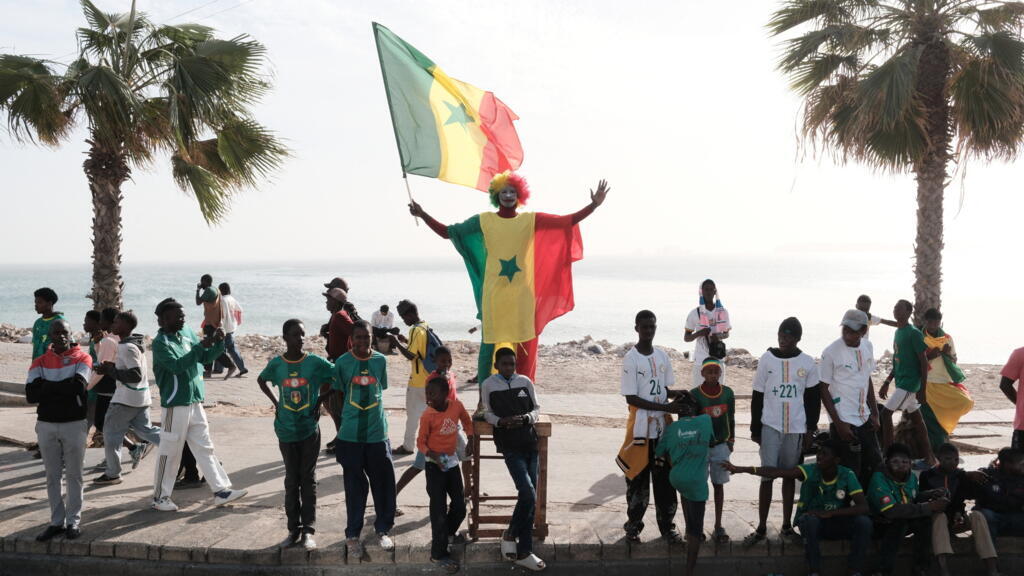Senegalese football fans parade through the streets of Dakar during a previous cup event, symbolizing the nation's passion for the sport.